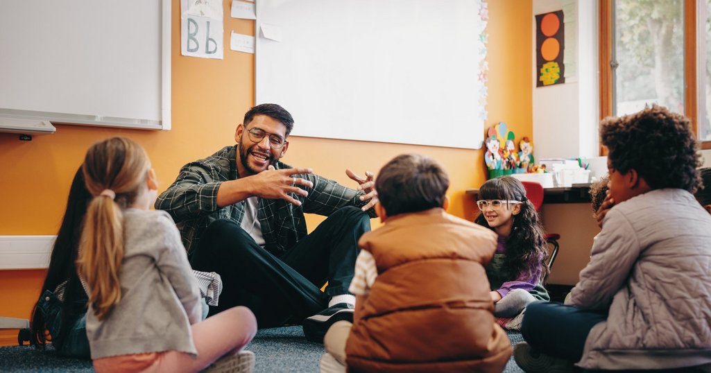Male educator talking to his students in a classroom. Man teachi
